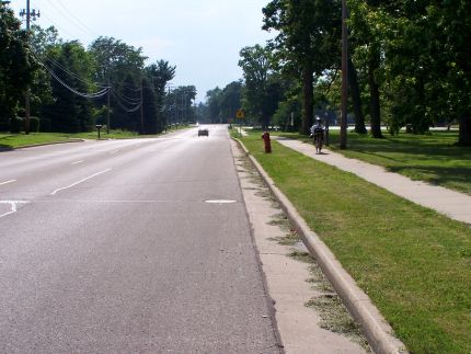 Bike path on sidewalk passing park