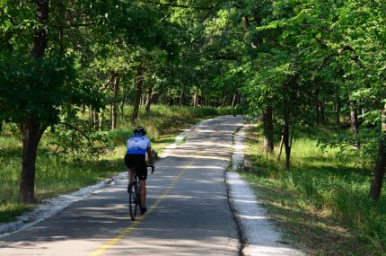 Cyclist crossing small stone bridge on NB Trail