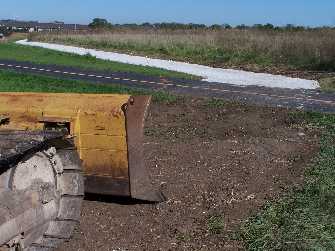 Tractor parked by bike trail upgrade project.